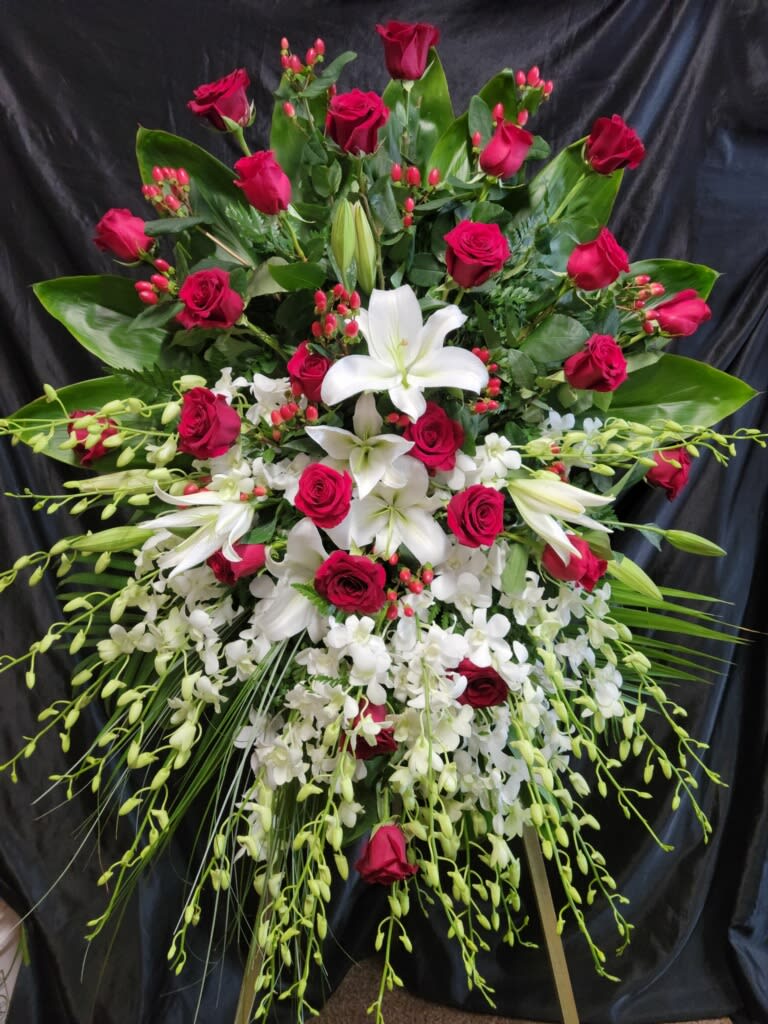 Premium Freestyle Standing Spray. PR # 1A - 24 Red roses  with White orchid sprays  Large White Lilies —we reserve the possibility to sub lilies with White Mums    ____SMALLER Version   Priced as 475.00