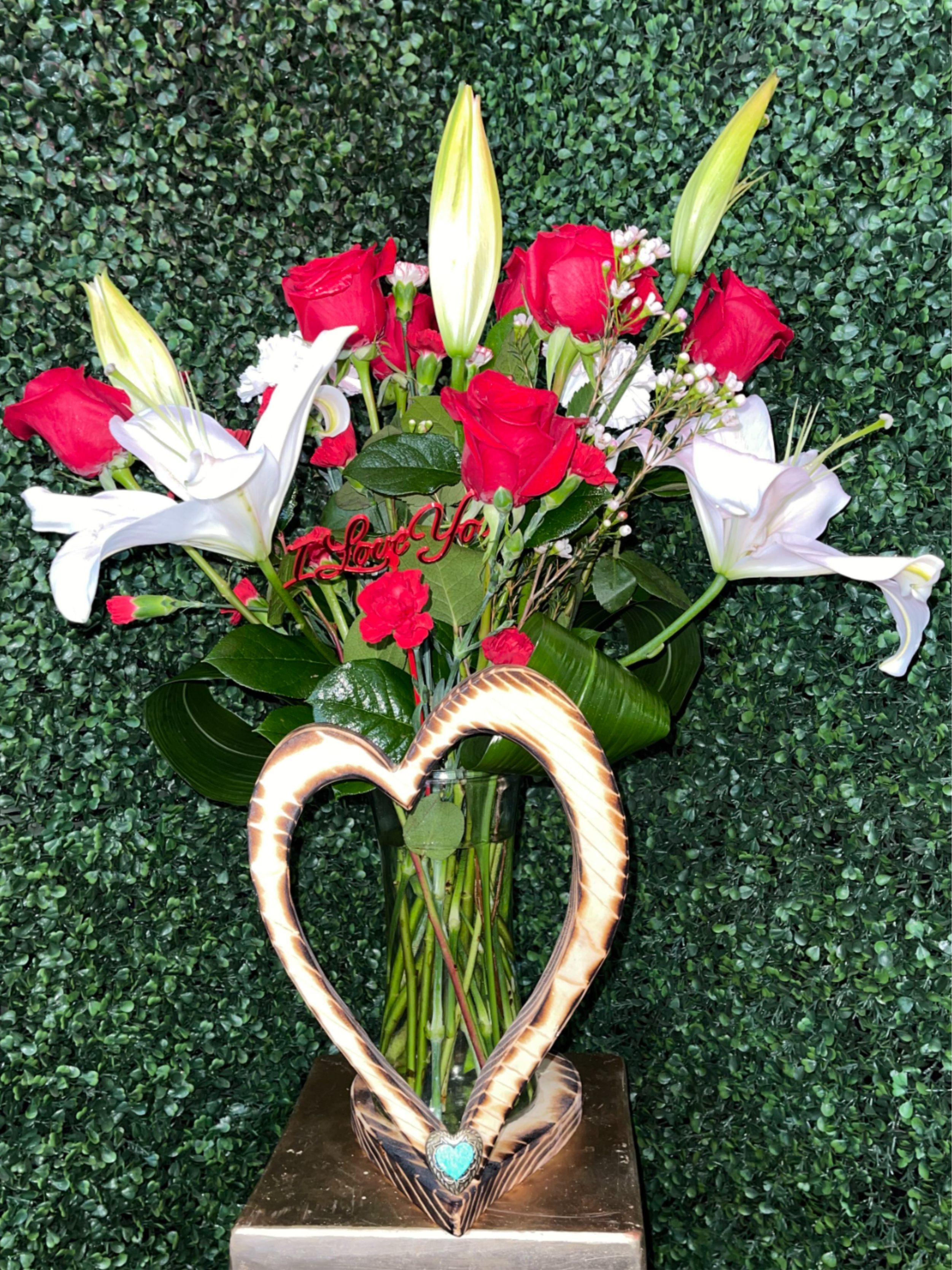 Only for you - A lovely wood-colored vase adorned with a wooden heart, filled with classic red roses, elegant white lilies, vibrant red mini carnations, and soft white carnations. This beautiful arrangement is sure to amaze anyone and makes a perfect Valentine’s Day gift.  * I love you pick not included*