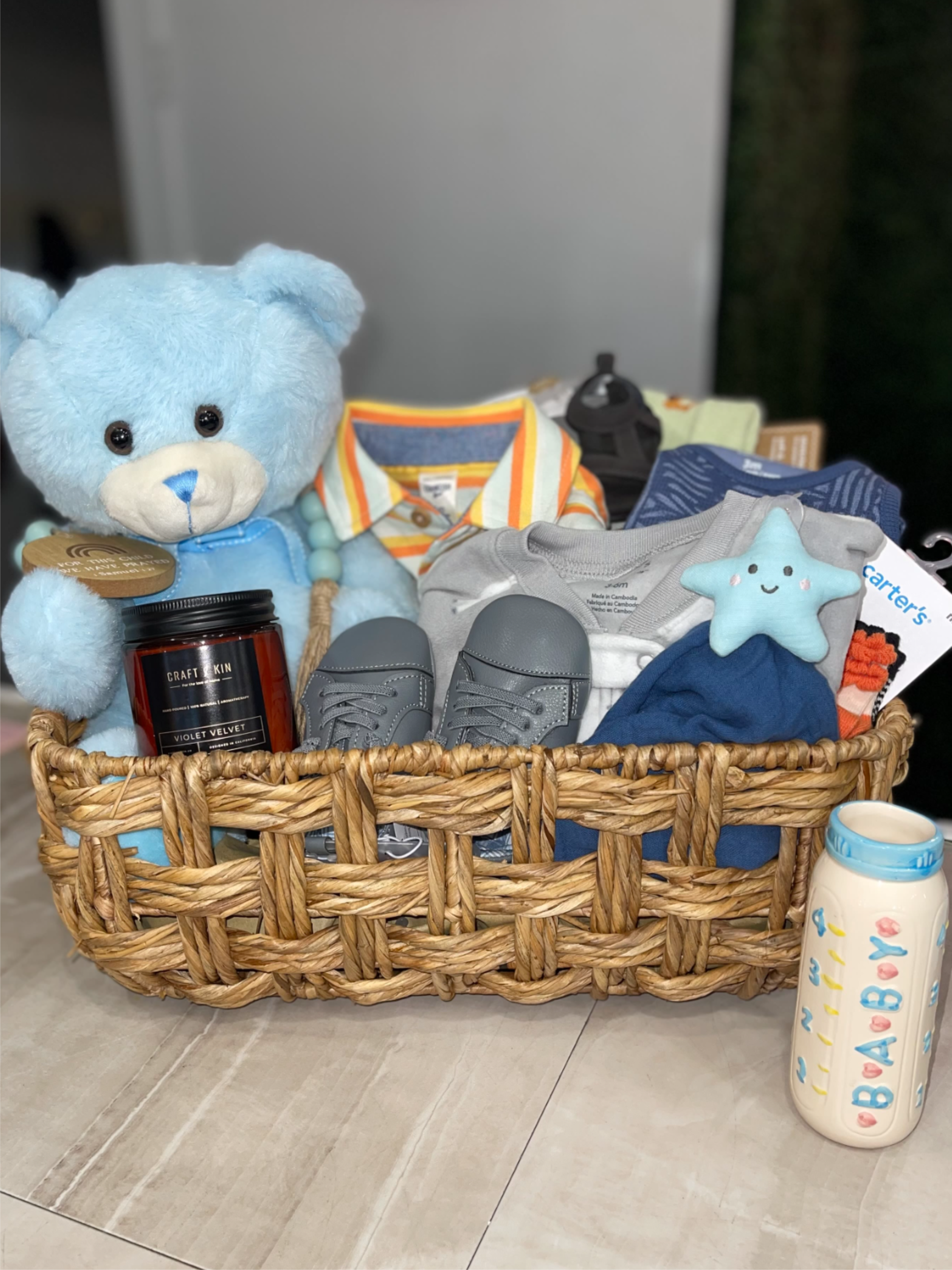 Hello Baby Boy Basket - Welcome the newest little guy home with a gift basket bursting with sweetness, snuggles, and smiles!  This ultra-adorable baby boy gift set is packed with cozy essentials for baby and a candle for the parents. From a super-soft starry blanket to a sweet plush bunny and a bottle vase that will be filled with fresh flowers this basket is the perfect way to say “Congratulations!” 