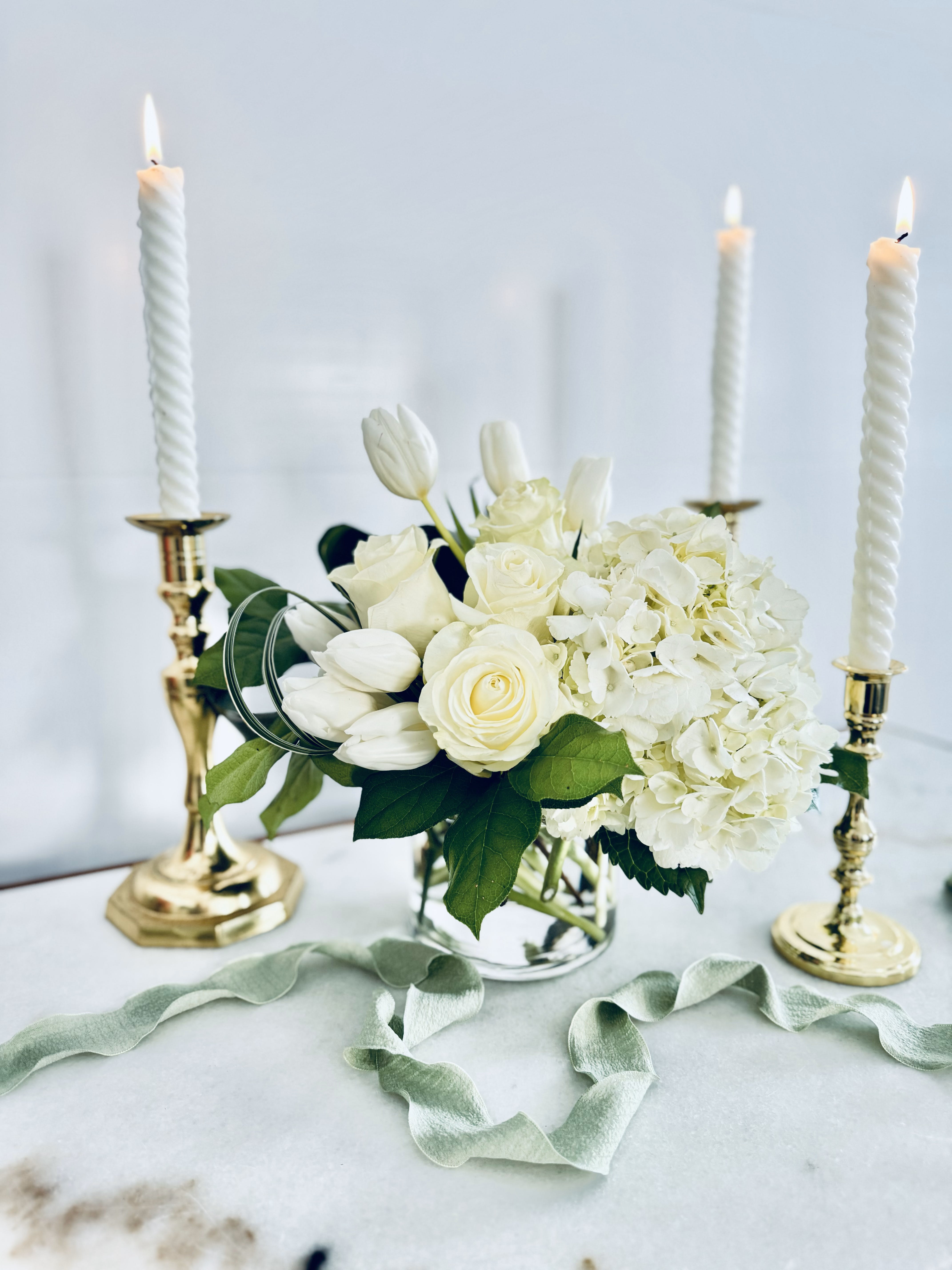 Aspen  (Seasonal) - TULIPS MAY BE SUBSTITUED WHEN NOT IN SEASON*  The Aspen arrangement is perfect for any occasion, from wedding showers and special events to corporate functions and intimate gatherings. The designers at Lilypots have expertly crafted this arrangement to suit any style, whether you prefer a classic or modern look. The result is a beautiful and timeless display that will add a touch of elegance and sophistication to any space.  To maximize the longevity and aesthetic appeal of our flowers, we recommend refreshing the water in your arrangement daily. Additionally, it's advisable to keep your arrangement away from all heat sources, such as warm air drafts, direct sunlight from windows, and stoves, among others.  As flowers are a natural product, it may be necessary to make substitutions of floral varieties on occasion due to various factors. The substituted florals will be selected based on their value, color, and overall aesthetic to match the original arrangement shown in the photos. 