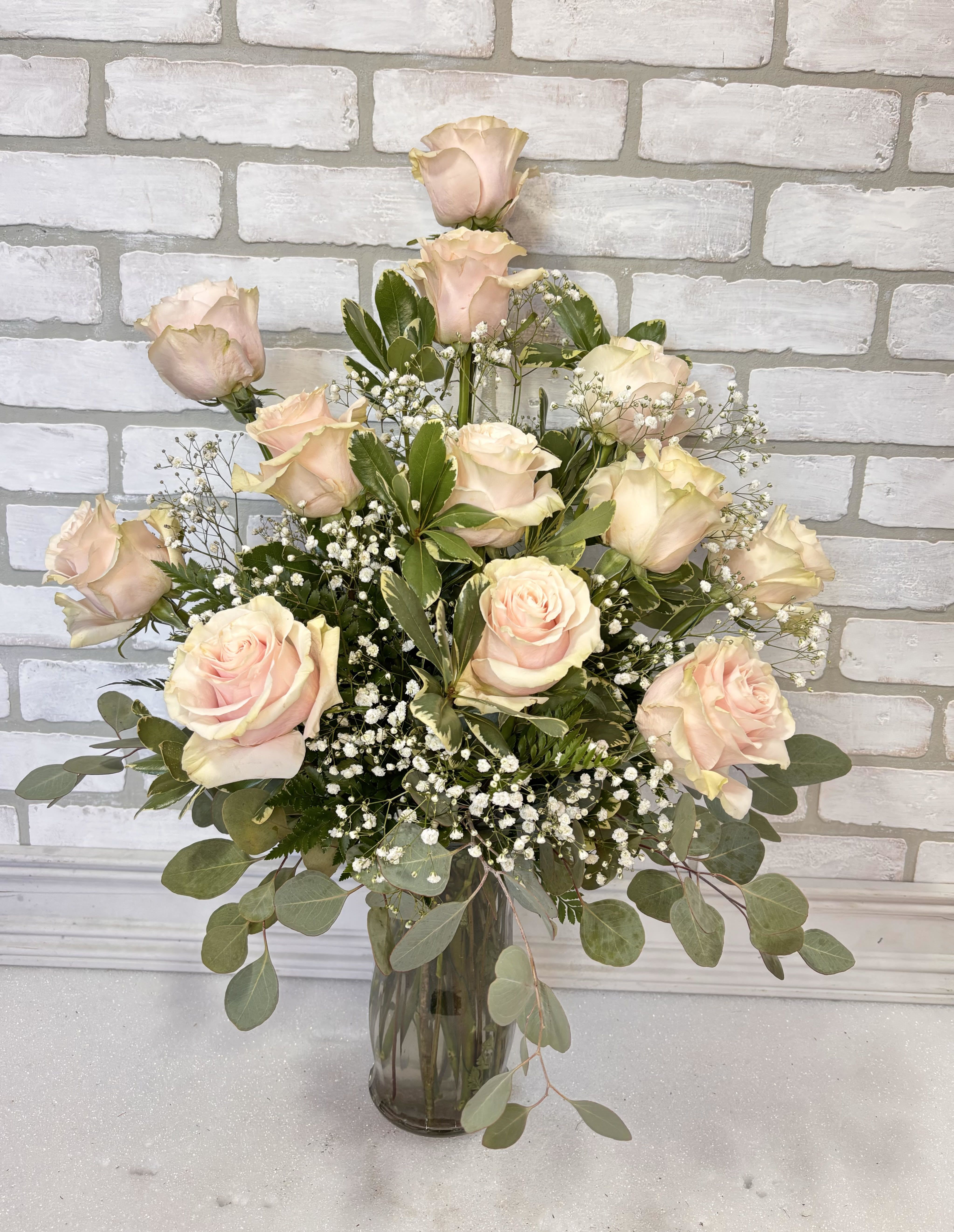 The Blushing Dozen Roses - 12 beautiful light pink roses arranged in a glass vase.  