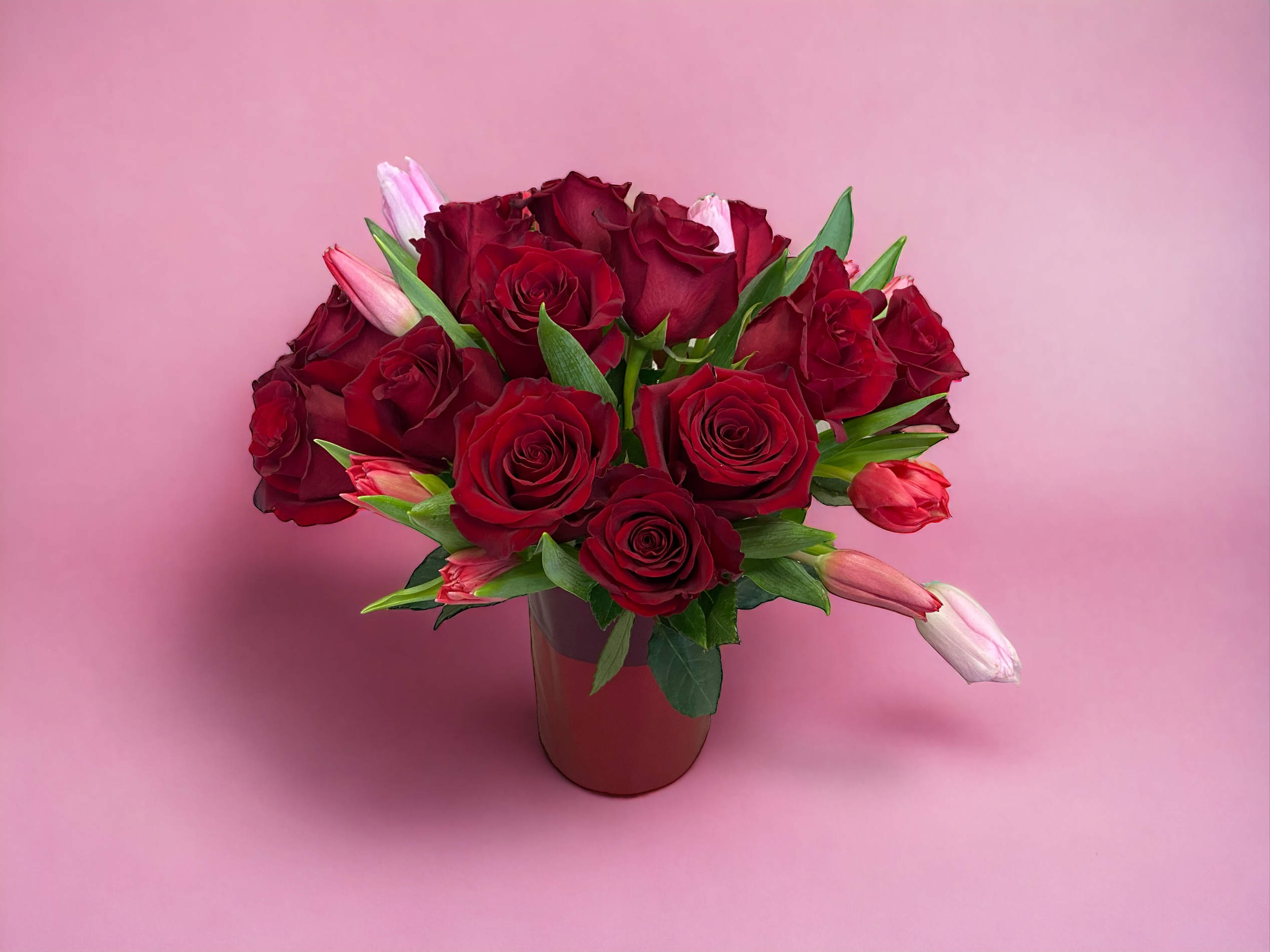 Red roses and tulips in a vase - A vase full of red roses and tulips for your house or as a gift.