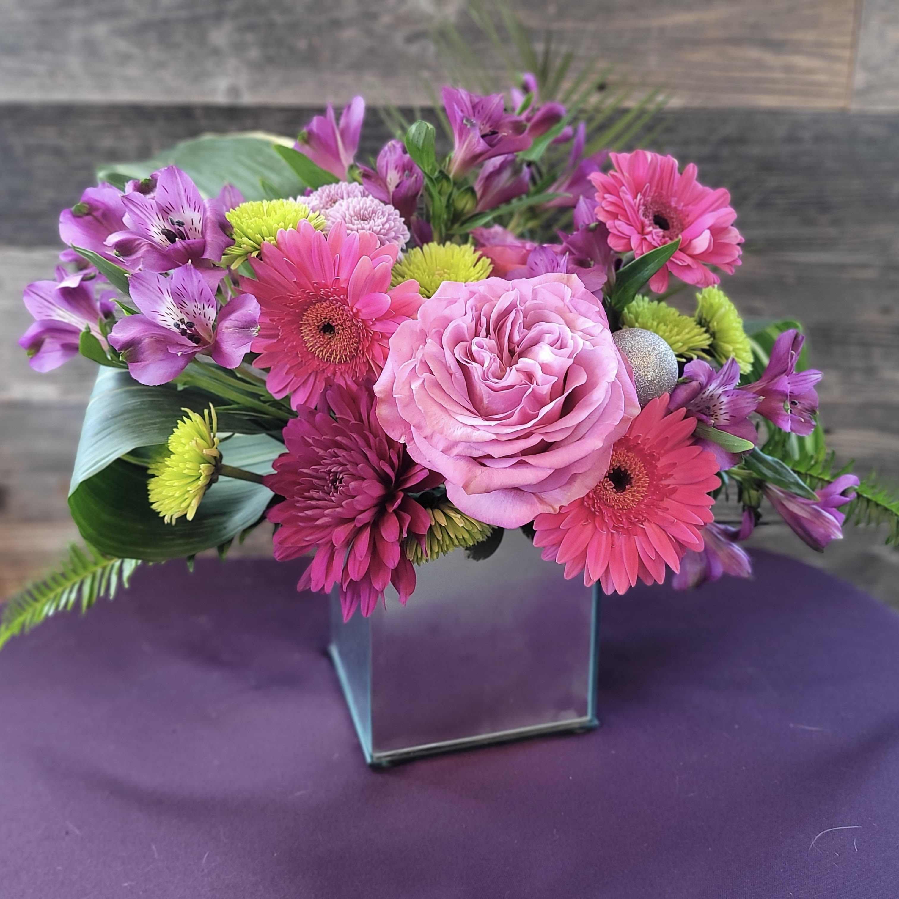 Groove - A bold, lively arrangement in a sleek, reflective vase, with vibrant colors and polished accents that feel ready to move to the beat. An arrangement that feels like a favorite song — full of rhythm, color, and life. Ideal for celebrations, milestone events, or anyone who loves a statement piece with personality.