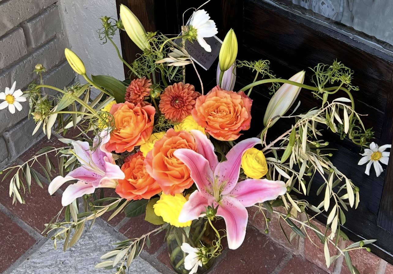 Sunrise Boulevard  - A radiant blend of coral roses, pink lilies, and sunny yellow blooms with meadow-style movement. Sunrise Boulevard brings the feeling of a new day — warm, confident, and full of possibility. Designed in Roxana’s signature natural, airy style, this piece is perfect for birthdays, congratulations, and moments that call for joy. 