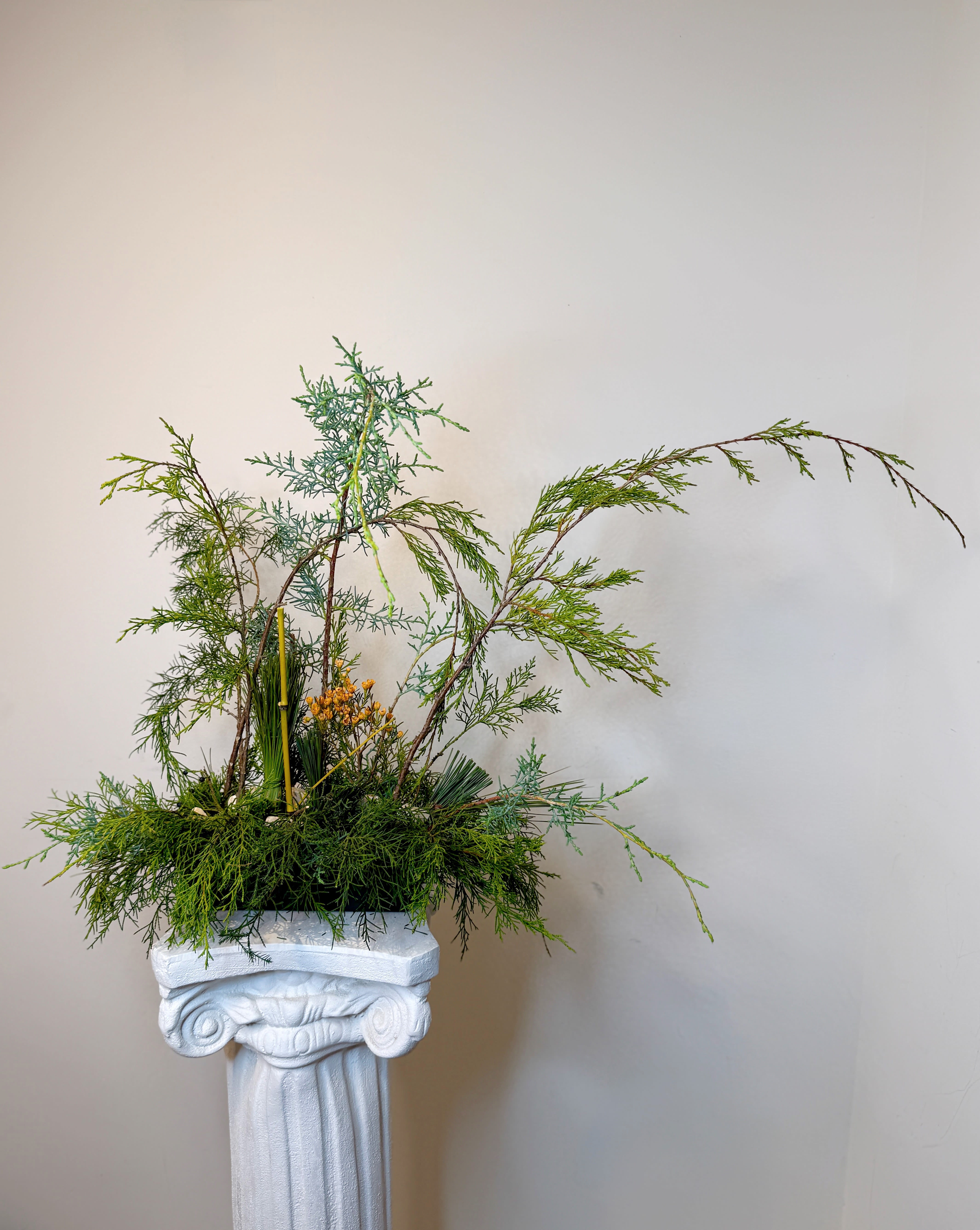 Green Silence  - A sculptural botanical composition created from carefully selected foliage and natural lines that interact with the space.    Designed as an interior design piece, this work does not seek to fill, but to balance.    Ideal for entryways, galleries, and spaces that understand luxury through calm and form.   One of a kind piece.