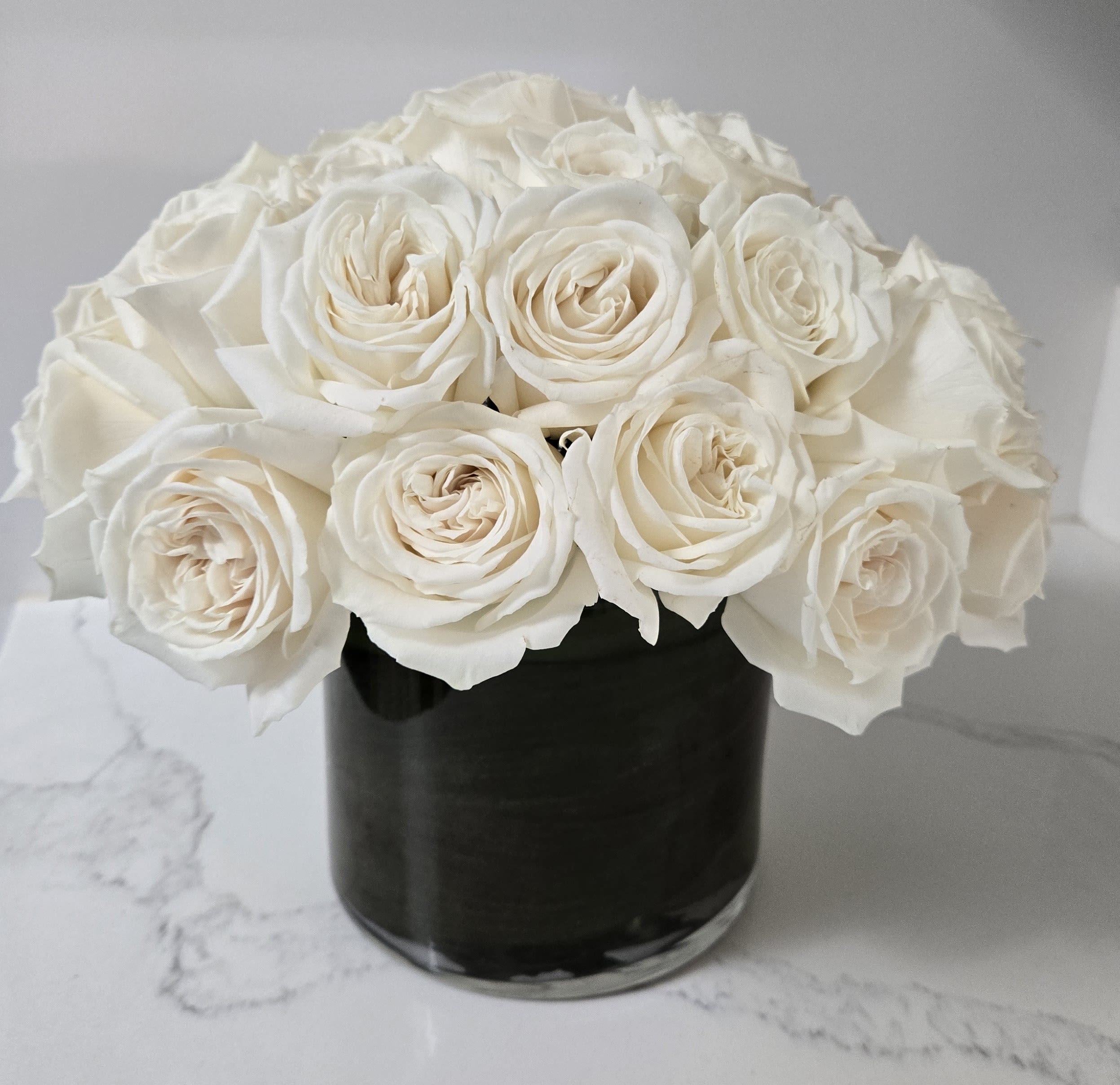 White Elegance - Simple yet elegant. Contains 36 stems of white roses.  Displayed in a clear glass vase.     
