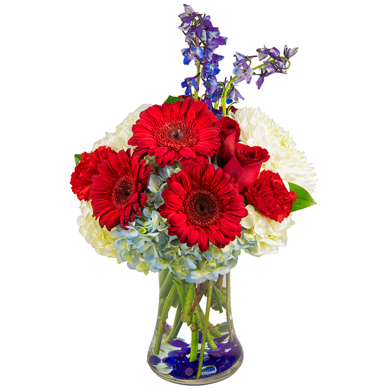 Blooms of Tribute - The Blooms of Tribute is handcrafted with Red Roses, Reg Gerbera Daisies, Red carnations, White hydrangeas, Blue Hydrangeas, White Mums, and Blue Delphinium.