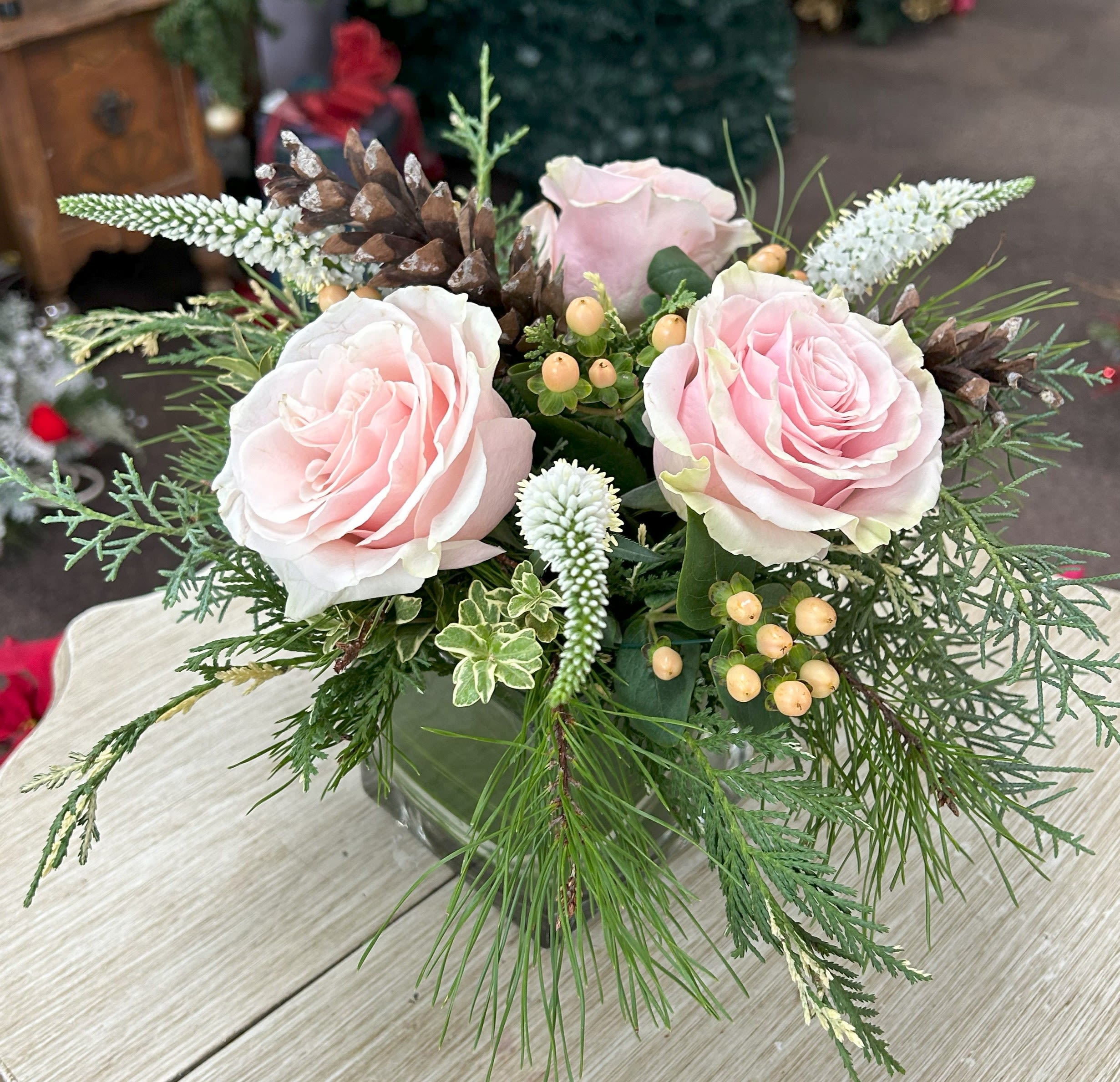 Light Pink Christmas Roses - 4" Cube with Christmas greens, light pink roses, veronica, hypericum berries, and pinecones. 