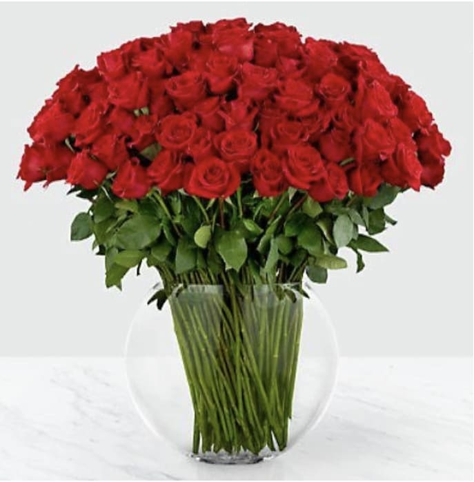 Breathless Luxury Bouquet - They leave you breathless with every kiss. Sweep them off their feet with 100 stems of our 24-inch premium long-stemmed red roses. Each stem flaunts the beauty of their beautiful swirling petals, gorgeously situated in a sophisticated clear glass 13-inch pillow vase, to astound and amaze your special someone with the bounty of their timeless elegance.