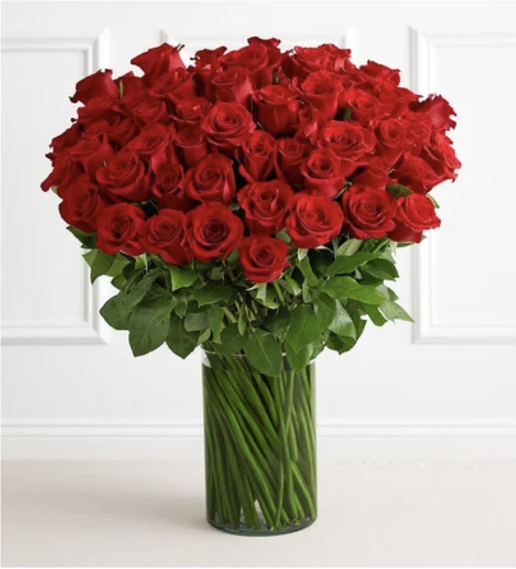 100 Long Stem Red Roses - Red Roses arranged in a glass vase with greenery. (vase shape may vary slightly from photo) LIMITED QUANTITIES