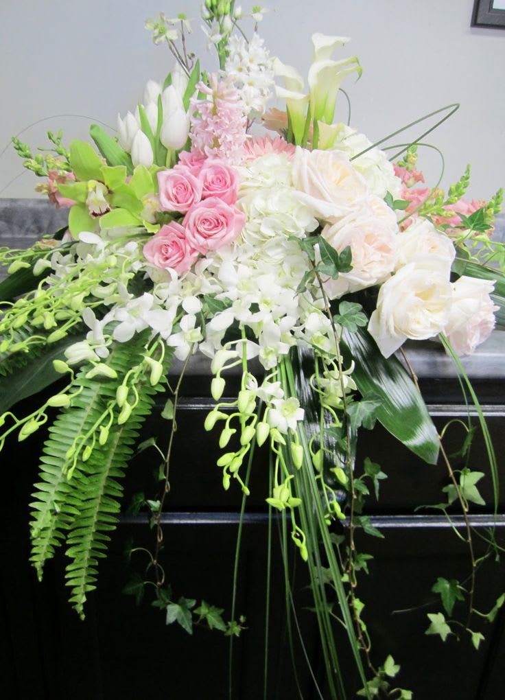 Granbury Flower Shop Sympathy Flowers- Wiley Funeral Home  - beautiful waterfall casket cover including white dendrobium orchids, blush roses, green cymbidiu, orchids, pink sophie roses, white tulips, fern, pink snapdragons, white hydrangea bear grass and ti leaves delivered to Wiley Funeral Home or Martins Funeral home, Sympathy flowers in Granbury