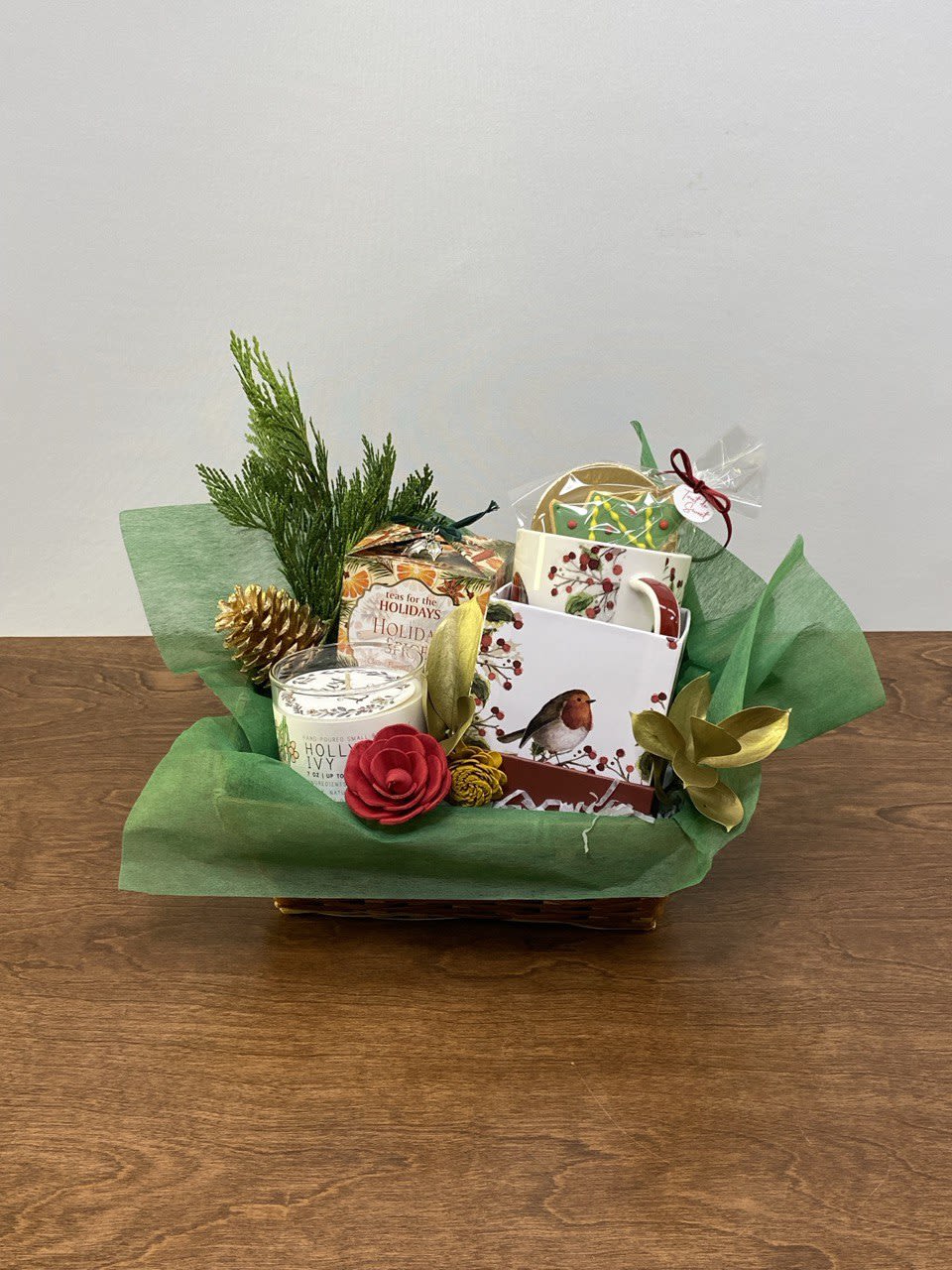Winter Tea &amp; Cheer Gift Basket - A cozy celebration of the season, our Winter Tea &amp; Cheer Gift Basket is perfect for quiet winter mornings or thoughtful holiday gifting. This charming basket features a holiday spice tea, a festive ceramic mug, a hand-poured seasonal candle, a decorated Christmas tree cookie, and natural winter greenery accented with pinecones and dried botanicals. A warm and comforting gift that invites moments of calm and joy.  For the delux version we add a beautiful holiday greeting card.  Perfect for: Holiday thank-yous, corporate gifts, teachers, and tea lovers.