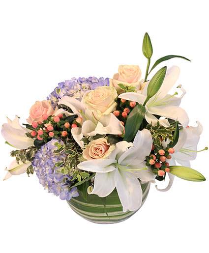 AURA OF WINTER FLORAL DESIGN - This beauty adds a colorful twist to your winter decor! Bring the season indoors with our beautiful Aura of Winter arrangement! With blue hydrangea, white oriental lilies, blue hypericum, light pink roses, and more, this blooming design is the perfect way to bring some warmth into your home. 
