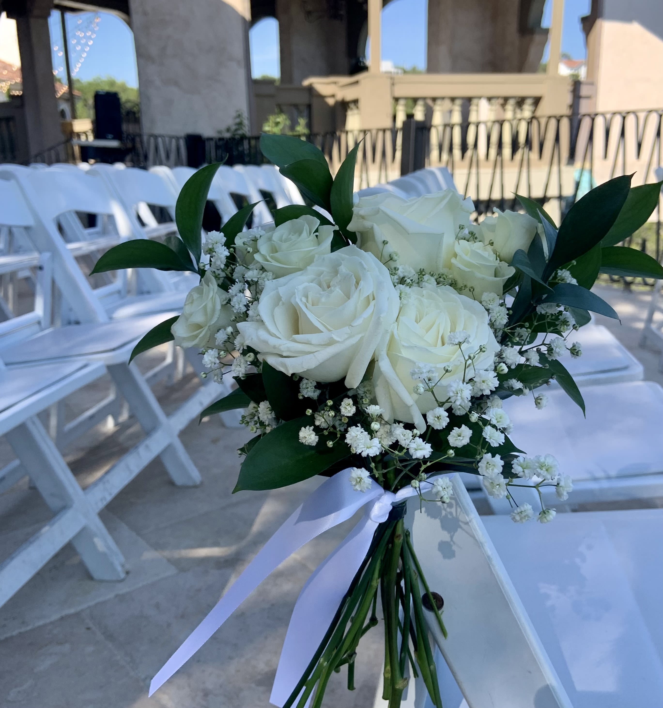 Garden Path Aisle Markers - The Garden Path Aisle Markers Transform your ceremony with our Garden Path Aisle Markers, designed to frame your walk toward the altar with high-end floral artistry. We offer three distinct tiers to match your vision, from delicate accents to immersive installations.  Tier 1: The Classic Petite Bundle Design: Delicate, hand-tied bundles of seasonal blooms and greenery.  Style: Secured elegantly to the side of chairs or pews with flowing silk or chiffon ribbon.  Impact: A charming, minimalist touch that adds pops of color to your pathway.   Tier 2: The Signature Lush Cluster Design: Full-bodied, mid-sized arrangements designed for the floor or atop small pedestals.  Style: A dense mix of premium focal roses and textures that creates a sophisticated border.  Impact: Provides significant volume and "wow-factor" for your ceremony photography.   Tier 3: The Immersive Meadow Installation Design: Large-scale, "grounded meadow" segments that appear to sprout from the floor.  Style: Lush landscapes featuring varying heights, premium garden roses, and airy stalks.  Impact: A high-end editorial look that transforms your aisle into a blooming garden path. 