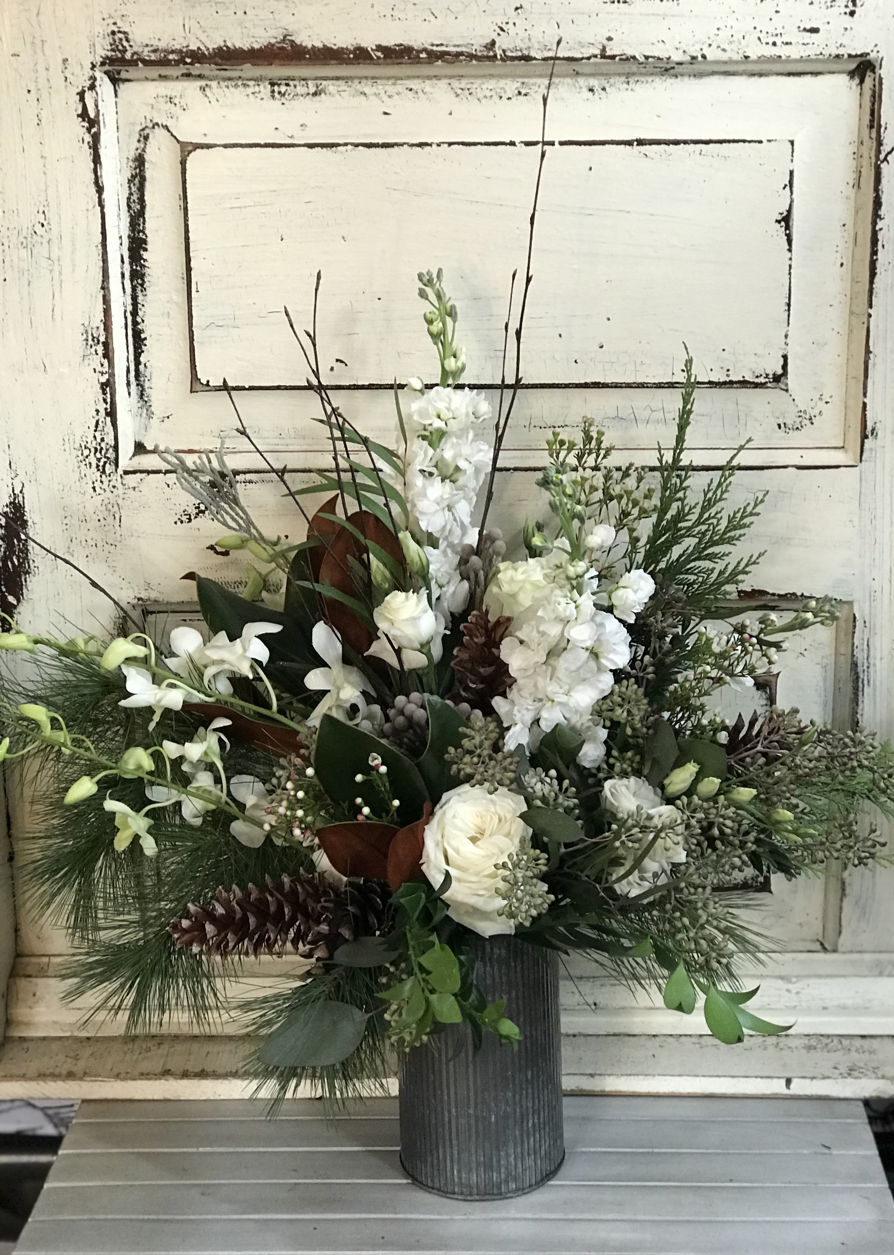 Winter White - Metal Vase - A winter-y mix of foliage, branches, berries and white blooms are arranged in a metal container for a perfect floral accent that to suit the season.