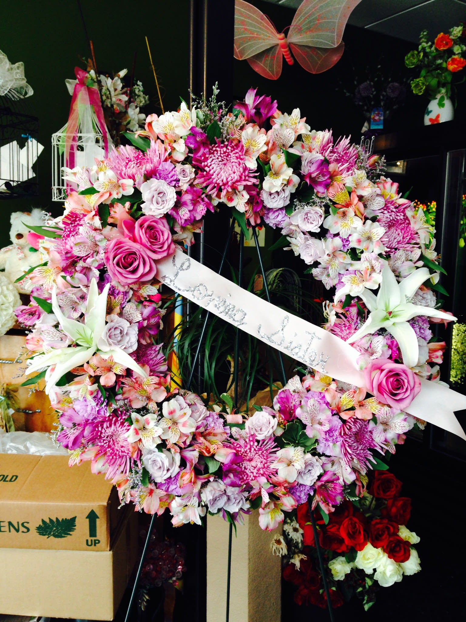 Love goes around... (In any color). A Floral Archist™ original. - Can be designed in a variety of colors. A standing spray to show your never ending love and the many memories that will never fade. A Floral Archist™ original.    Approximately 22”- 24”. One-sided design.