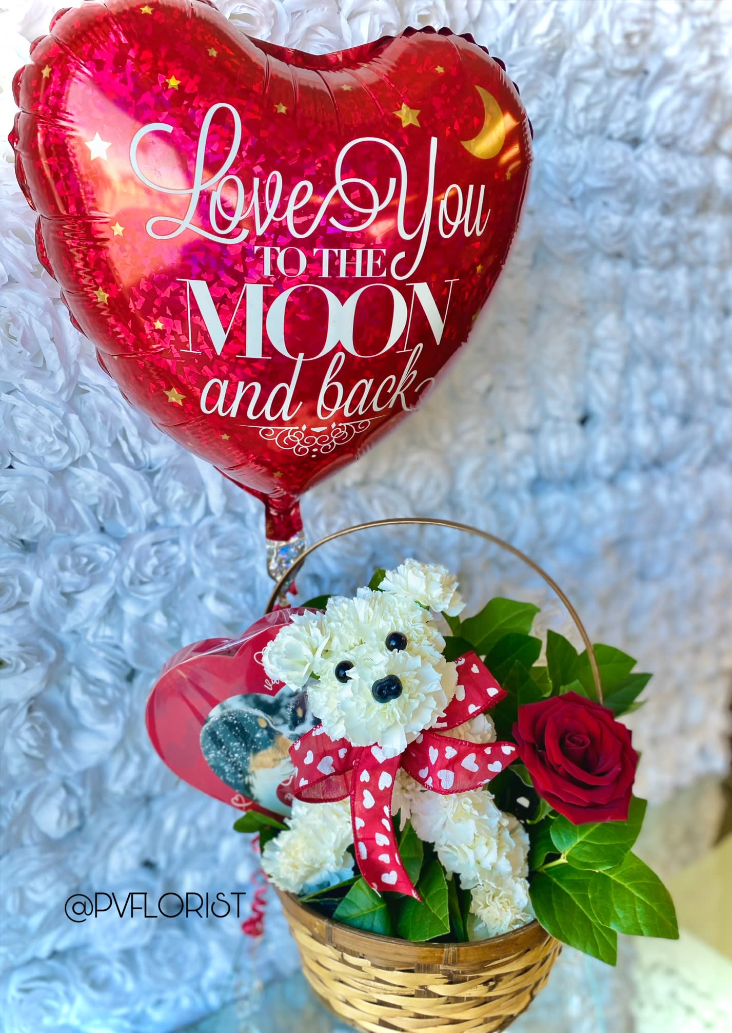 Fifi in love - Today Fifi is seeking a Valentine. This cute as can be dog is made of carnations!  Fifi comes with a small box heart Chocolates, One heart Mylar and One rose. Upgrades will add additional roses, Mylar balloons and larger chocolates.  Rose color will vary depending on availability. Please specify if a specific color