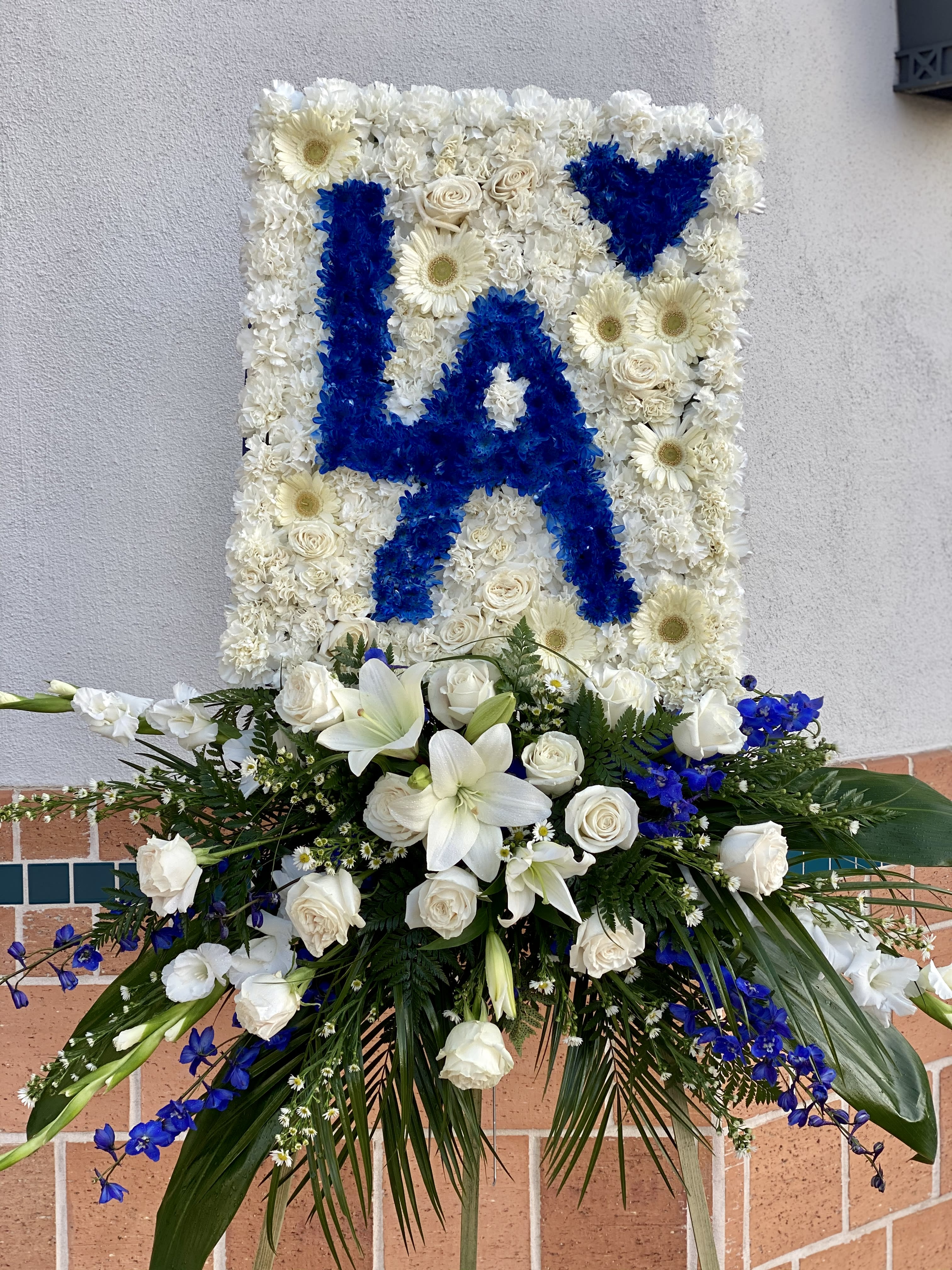 #1 Dodgers Fan - #1 Dodgers Fan Tribute Celebrate the life of a devoted sports fan with this stunning funeral arrangement. Perfect for honoring a true Dodgers supporter, this piece can be customized for any team and in any color combination, creating a personalized and meaningful tribute. 