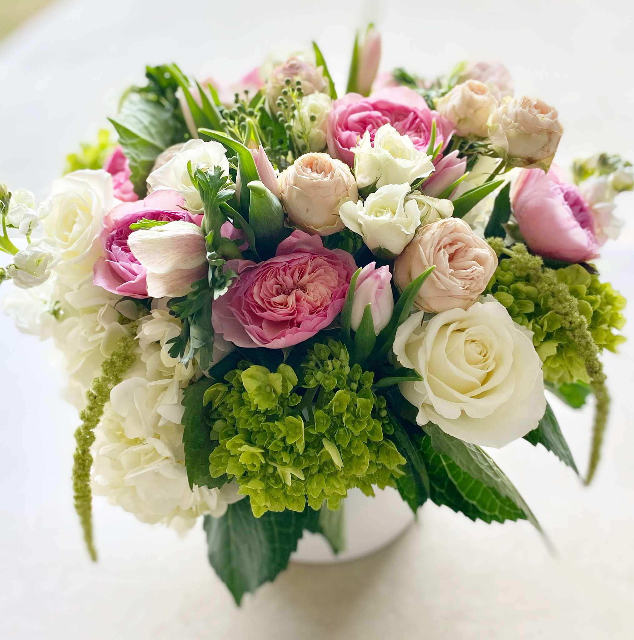 Pink and blush bouquet  - Blossoming, gentle and innocent. Tailor-made to induce a big smile for the recipient. Designed and hand-crafted with a variety of seasonal, fresh, high-end flowers in a pastel color palette.  Container is a 6" glass or ceramic white vase. Pictures are not exact duplicates of what we will be making, but rather are samples of our creations and design style. However we will make every effort to stock and use flowers shown. All arrangements will be DESIGNERS CHOICE based on flower availability in the particular COLOR PALETTE you are choosing. For same day delivery, call us at 949-682-5004.