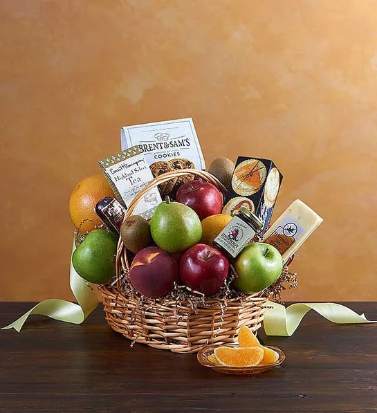 Fruit and Gourmet Basket - The gift of good taste! Send this gourmet gift basket of fruit and snacks to a gracious hostess, busy new parents, or anyone who appreciates the finer things in life. Hand-delivered, the basket overflows with delicious fruit and tasty treats. Apples, pears, oranges, grapes, bananas and a pineapple are presented with cheeses, crackers, tea and other savory snacks in a natural gift basket that's trimmed with a bow.