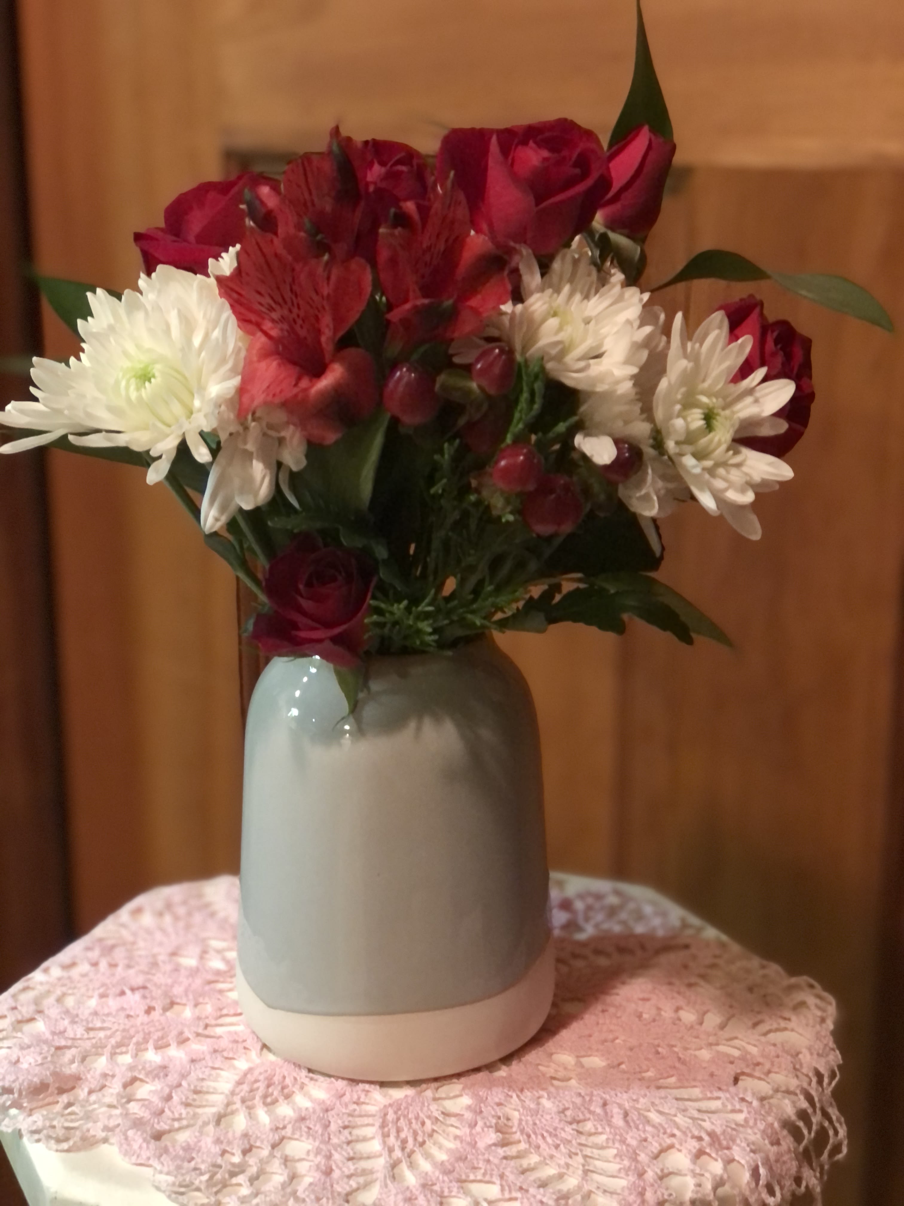 Modern Farmhouse Chic  - Our Modern Farmhouse Chic starts with a 5" Earl Grey churn vase. Created out of ceramic material made from stoneware clay finished with a satin glaze. We add in fresh spray roses, mums and seasonal blooms. Accented with hypericum berries and assorted greenery. Sure to bring a smile to someone's face or even your own.   We can chance up the colors of the flowers to fit any season or occasion. Just call and we can discuss colors, feelings or moods you are trying to convey. inventory count: 5 The Deluxe and Premium will be in a 6.5" vase. Picture of Vase shown in the deluxe picture. ( Flowers will be added) 