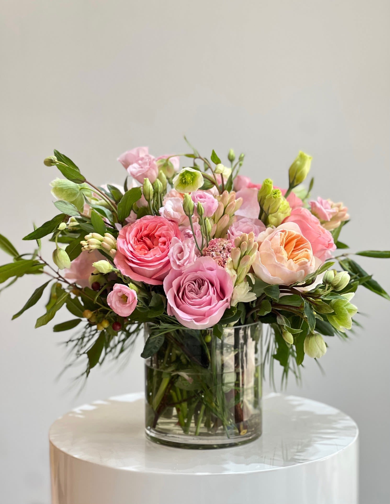 Sentimental Love™ - This radiant arrangement bursts with personality, blending peach and coral roses, soft pink Lisiantus, and vibrant greenery. Presented in clear glass vase, it’s a cheerful yet sophisticated centerpiece that brings a fresh, uplifting energy to any space.