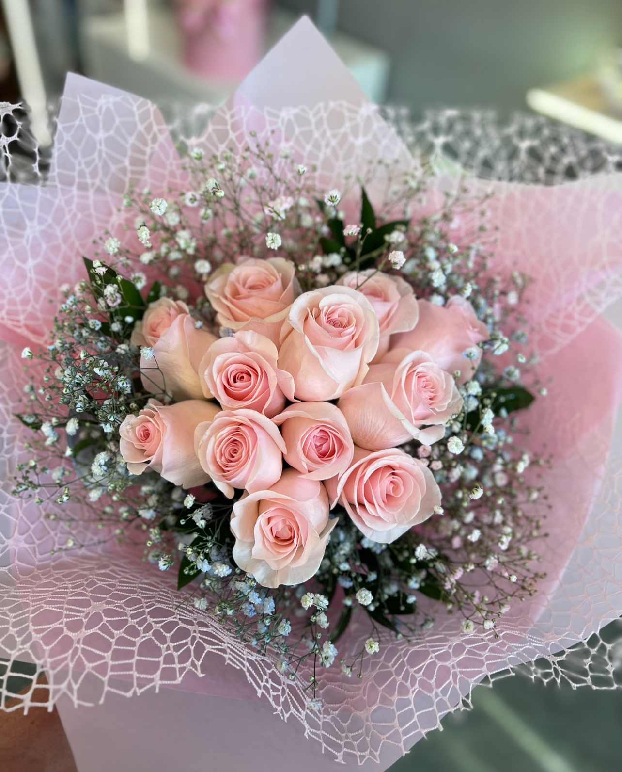 Delicate ™ - A timeless bouquet of velvety blush roses, wrapped delicately with airy baby’s breath and greenery. Finished in soft pink lace-style wrapping, it’s the perfect gesture of elegance and charm.