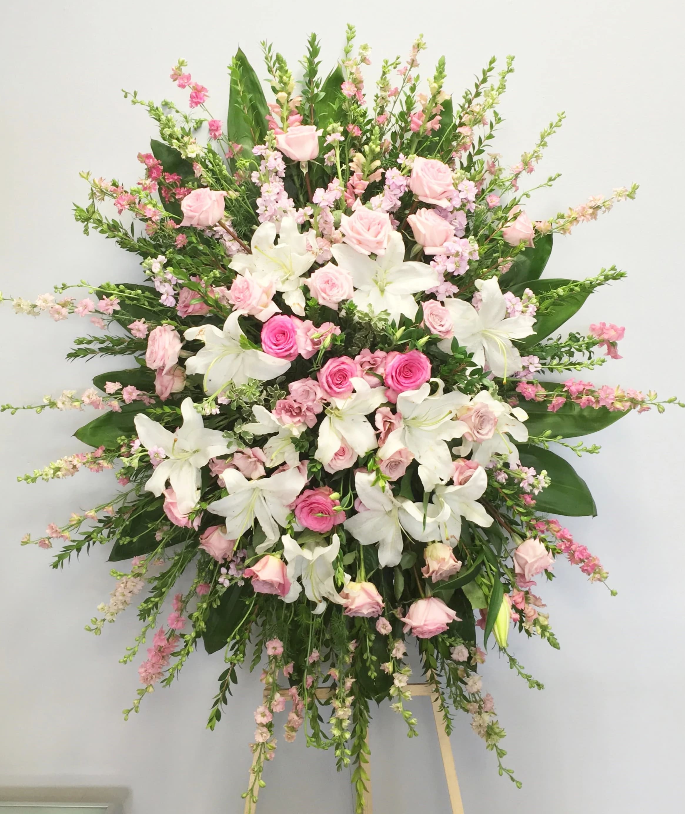 Sweet Pinks Spray - Sweet pinks is a beautiful standing spray of warm pinks and white, accented with tropical seasonal greenery to make for a heartwarming arrangement.