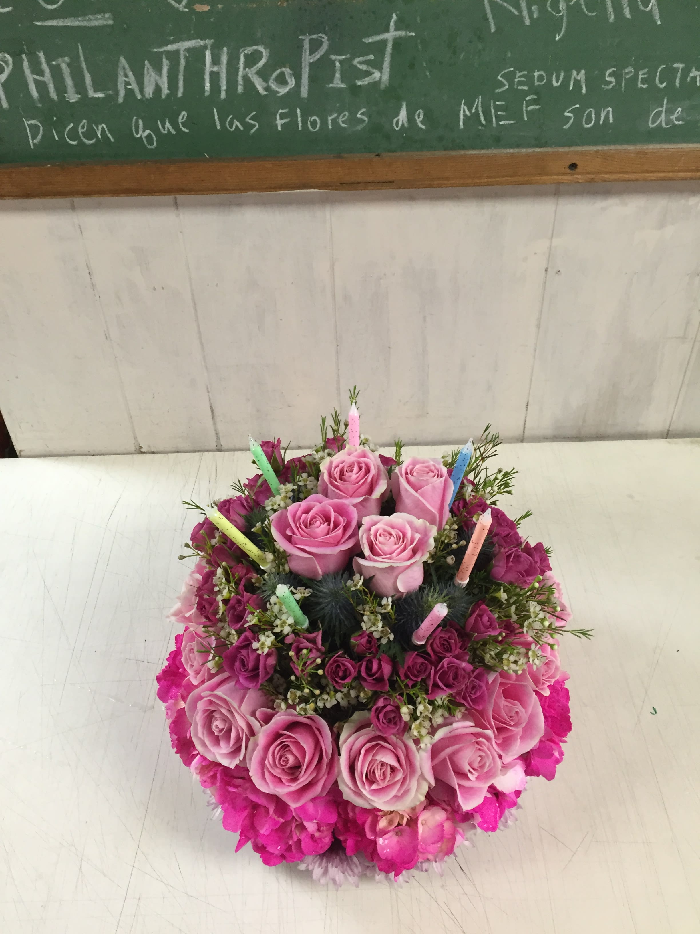 A very Happy Birthday cake mef 0903 - one way to celebrate a birthday by giving them a beautiful birthday cake of flowers! including pink roses, pink waxflowers, pink hydrangea, lavender mums, blue thistle and candles