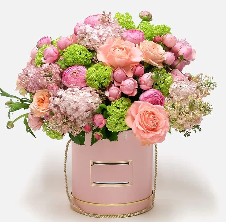 Garden Gala arrangement -  Step into the "Garden Gala," where floral elegance meets vibrant charm Bright fluffy pink and green flowers sitting in a perfectly pink hat box.