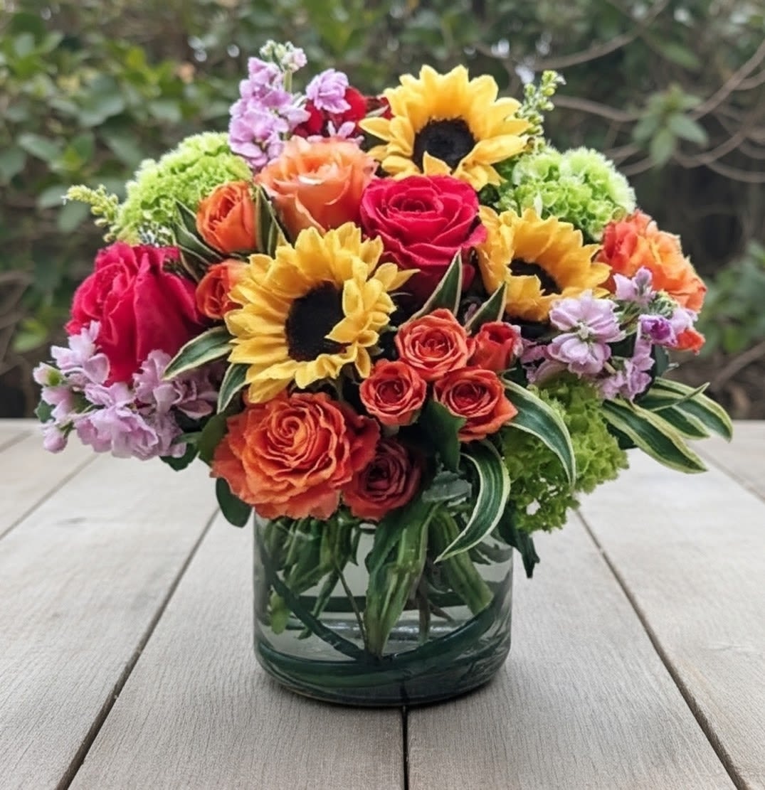 Garden Party - This abundant &amp; vibrantly colored premium bouquet is full of the freshest blooms like sunflowers, spray roses, garden roses, fragrant stock, hydrangeas and more! It's perfect for celebrating birthday's &amp; sending get well wishes. Arranged in a large clear glass cylinder.   Measures approx. 14" tall &amp; 16" wide Orientation: All around