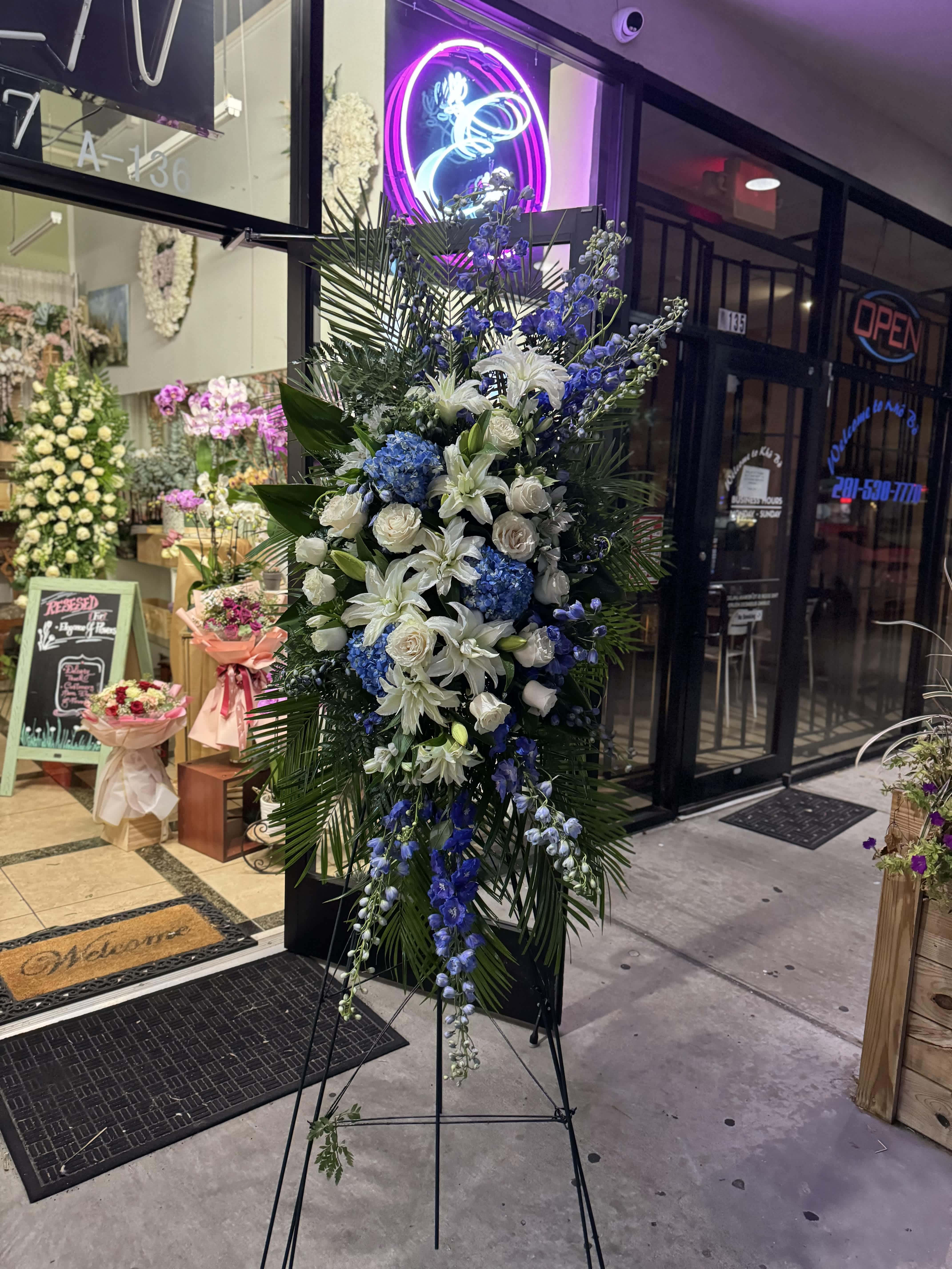 Easel #3 Online - A standings flower arrangement for a funeral service is a heartfelt tribute designed to honor and celebrate the life of the deceased. These arrangements are typically displayed on an easel or stand, making them highly visible and a central part of the memorial decor. 