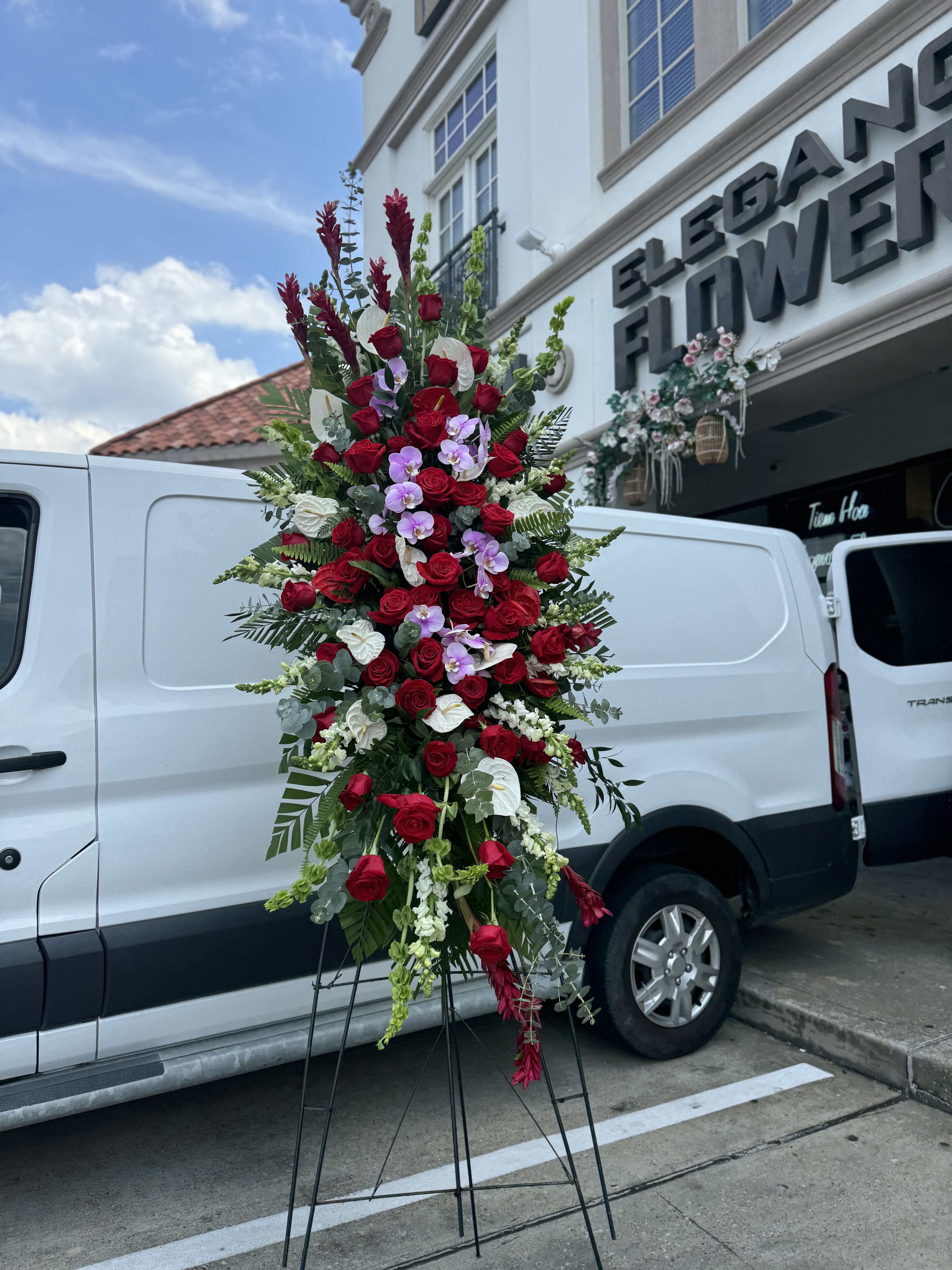 Easel #19 Online - A standings flower arrangement for a funeral service is a heartfelt tribute designed to honor and celebrate the life of the deceased. These arrangements are typically displayed on an easel or stand, making them highly visible and a central part of the memorial decor.