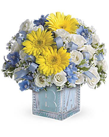 Baby Boy's First Block - He'll be building block towers soon enough! For now, celebrate him with this beautiful keepsake baby block. Filled with soft blues and whites, the glass block can be used later in baby's room and makes a memorable baby boy gift. A baby blue ribbon weaves through white spray roses and blue delphinium in a keepsake glass baby block vase. Orientation: All-Around