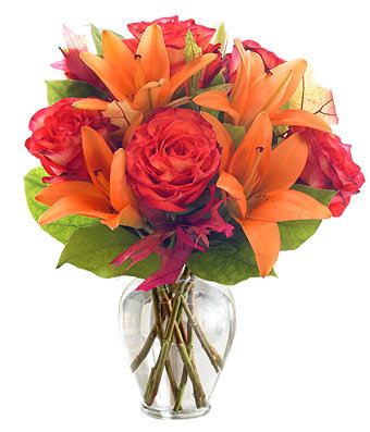 Orange Sorbet - Orange Roses and Lilies with mixed greenery in a clear glass vase.