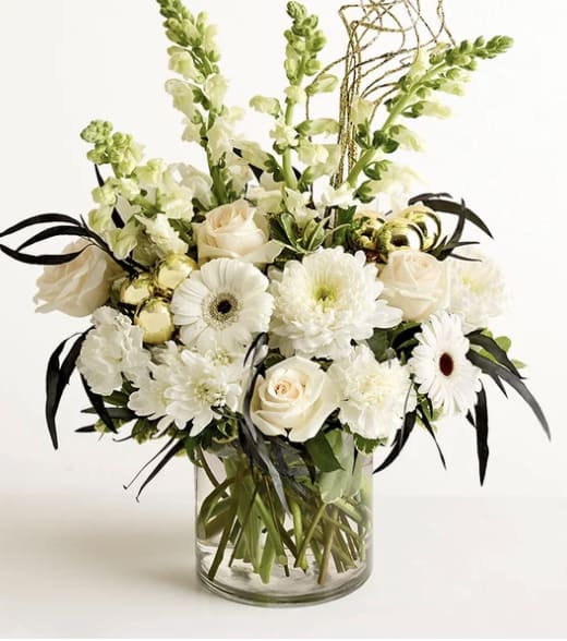 Hello New You - This bouquet is cause for celebration in and of itself! White roses, snapdragons, and other blooms provide the timeless elegance; golden curly ting and ball ornaments, along with eucalyptus sprayed black, serve up plenty of glamour.
