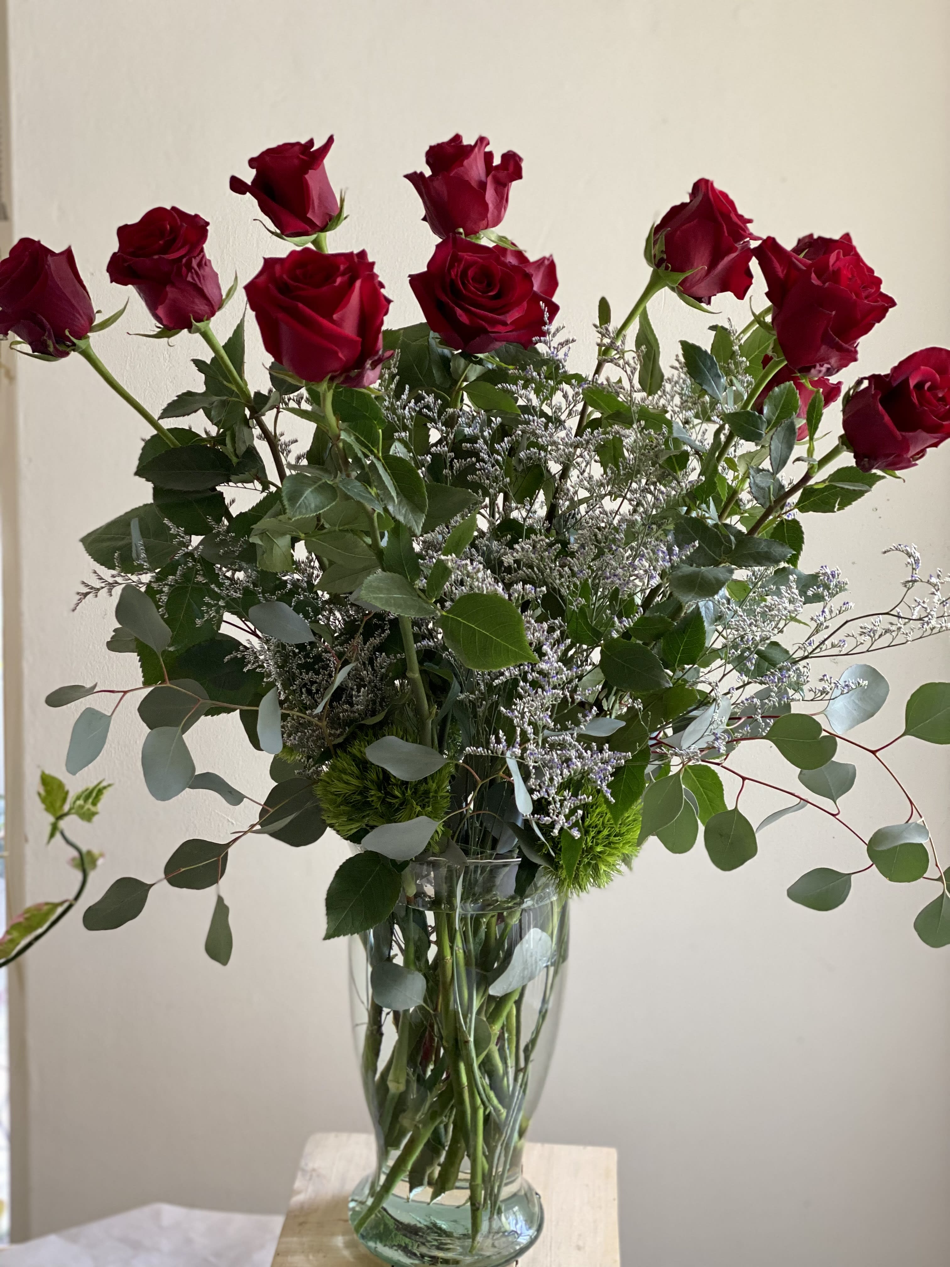 Art Le Fleur Roses by the dozen - A charming arrangement of a dozen or two dozen high-quality, long-stemmed, fresh red roses, adorned with textured greenery is a classic expression of romance. Delivered in a clear glass vase,  this bouquet is also a romantic standard for any day of the year. Available also in White, Purple, Pink, Yellow, Orange, etc. Let us know what your request is and we will strive to make it happen. Deluxe option includes 2 Dozen roses (24). Premium option includes 4 Dozen Roses  Your personalized card is always handwritten and always free with Art Le Fleur!