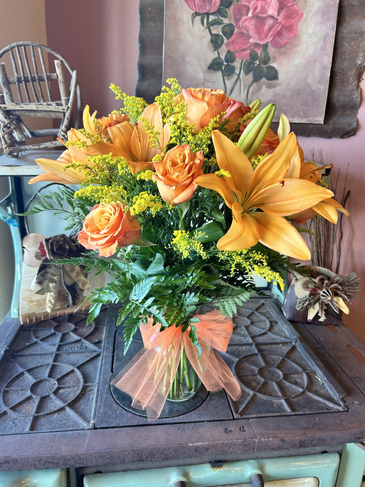 Fiery Lily and Roses - This radiant bouquet is full of flowers and fiery beauty, it makes a beautiful gift for any occasion. Features dark orange roses and orange Asiatic lilies in a charming glass vase.