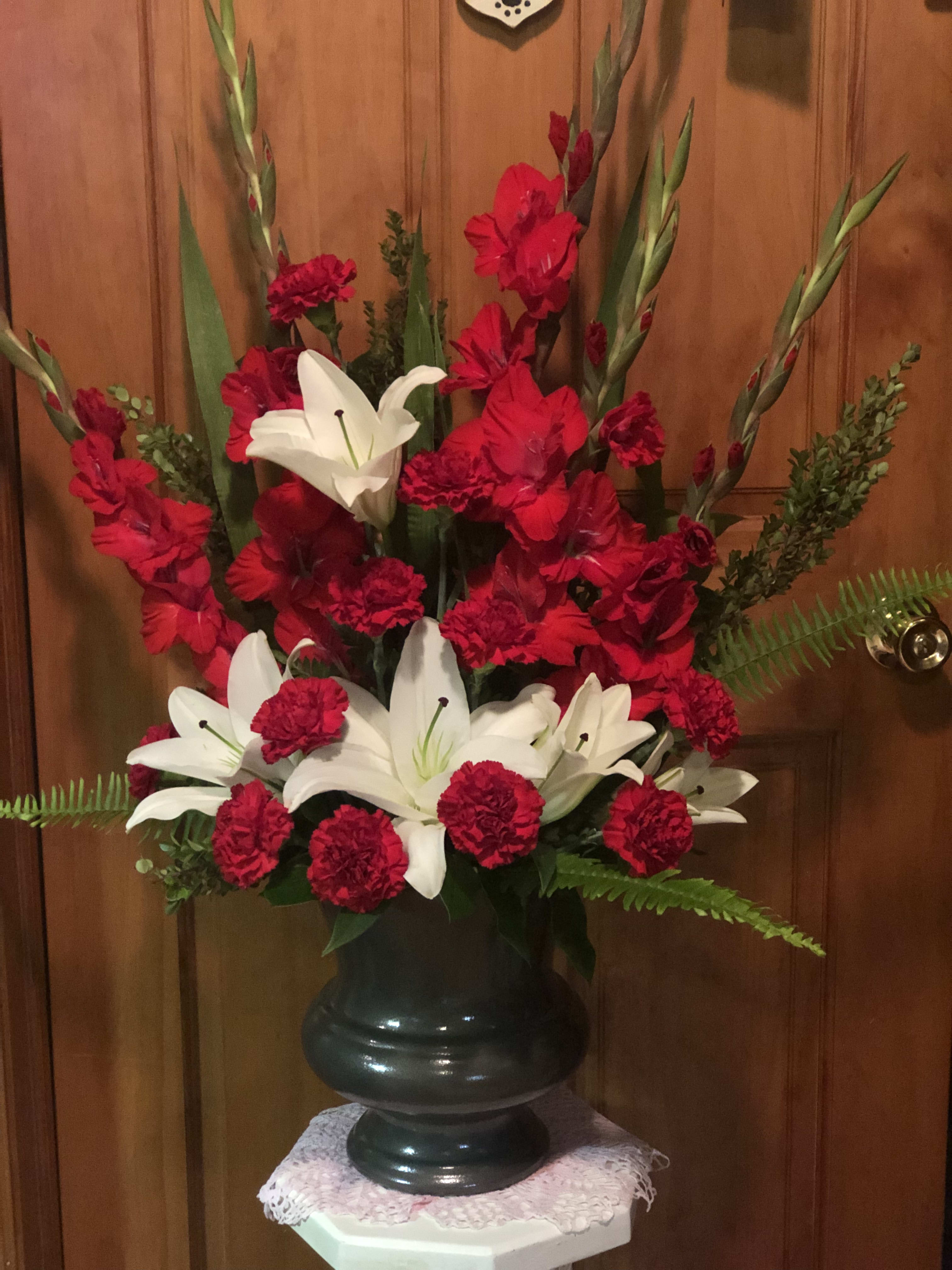 Red and White Tribute  - A contemporary statement of Red Gladiolus paired with Red Carnations and White Lilies mixed with sword fern and boxwood. If you would like a ribbon &amp; wording, i.e., loving friend, Dear Mother, In-Law, Nephew, etc. Please call us for pricing.