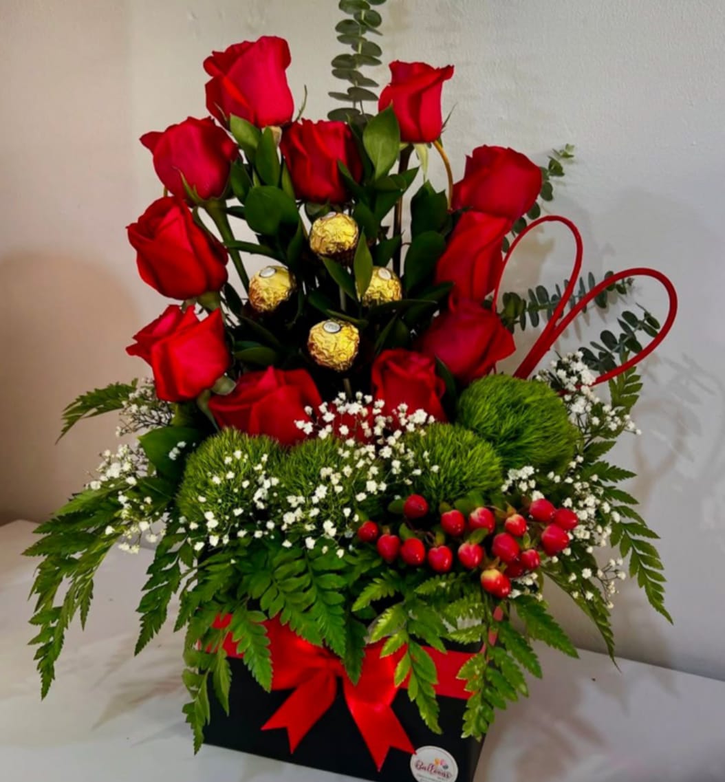 Sweet Surprise Roses - This charming floral gift features fresh 12 red roses paired with assorted chocolates, beautifully arrangement with lush greenery and festive acents by Snyder Flowers, a trusted florist in San Antonio TX. Perfect for birthdays, anniversaries, romantic surprises or just because, this arrangement is ideal for customers searching for flower and chocolate delivery in San Antonio, a local San Antonio flower shop or same day flower delivery. A sweet and thoughtful design that delivers love, joy and a memorable surprise.