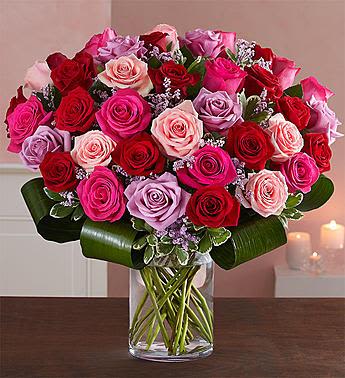 Lavish Love Bouquet - Let her know your love is forever with a sensational surprise she’ll remember forever! We’ve hand-arranged 50 timeless roses in striking shades of red, pink and lavender inside a stylish cylinder vase for the ultimate romantic gesture. And because one amazing gift deserves another (and another…and another!), pair these gorgeous blooms with our huggable plush bear, decadent chocolates and “I Love You” balloons!  Our florists hand-design each arrangement, so colors, varieties and container may vary due to local availability All-around arrangement of 50 roses in red, light pink, hot pink and lavender; accented with pink limonium, aspidistra leaf and variegated pittosporum Artistically designed in a clear glass cylinder vase; measures 8"H Arrangement measures approximately 24"H x 20"L  Add to her gift:  Small bundle includes flower arrangement and vase only Medium bundle includes cuddly plush bear and 8 oz box of chocolate; bear measures 10"H; safe for ages 3 and up Large bundle includes bear, chocolate, and five 18"D Mylar “I love You” balloons Bear, chocolates, and balloon designs may vary due to local availability