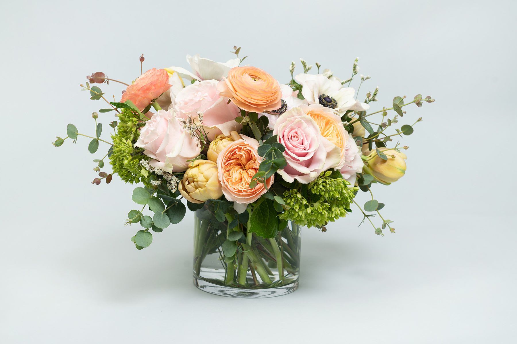 Harbor - Harbor is a refined blend of blush and peach roses, creamy ranunculus, crisp white anemones, and fresh seasonal greenery. Designed in Studio C’s signature airy, garden-inspired style, this arrangement feels soft, elevated, and timeless—perfect for winter gifting, New Year’s celebrations, and thoughtful everyday moments.  Each Harbor arrangement is thoughtfully designed using the freshest seasonal blooms available. While flower varieties may vary slightly based on availability, the overall palette, size, and style will remain true to the photo shown.  Photo displays deluxe size.