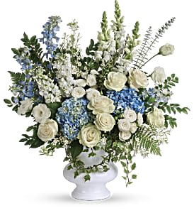 Treasured and Beloved Bouquet - A treasured tribute to your beloved, this gorgeously grand bouquet of soft blue hydrangea and pure white roses is reminiscent of a clear sky, a hopeful reminder of life and love. This beautiful bouquet of light blue hydrangea, white roses, white spray roses, white lisianthus, light blue delphinium, white snapdragons, white stock, and white waxflower is accented with huckleberry, variegated ivy, spiral eucalyptus, dagger fern, and lemon leaf. Delivered in a white designer urn. Approximately 27 1/2" W x 29 1/4" H