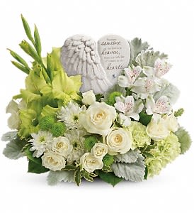 Teleflora's Hearts In Heaven Bouquet DX - A heartfelt expression of your sympathy, this majestic mix of white roses will rejuvenate the spirit. Nestled among the blooms is a graceful angel's wing keepsake, etched with an encouraging message they'll cherish forever. Message on sculpt reads: "Because someone we love is in heaven, there is a little bit of heaven in our hearts." White spray roses, white alstroemeria, green gladioli, green carnations, green button spray chrysanthemums, and white cushion spray chrysanthemums are accented with dusty miller, pitta negra, and lemon leaf. Delivered with a Heaven's Heart keepsake. Approximately 16" W x 13" H