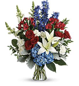 Colorful Tribute Bouquet - Perfectly patriotic with its red, white and blue blooms, this bold bouquet of hydrangea, lilies and roses is a versatile tribute on any occasion. This bouquet features blue hydrangea, red roses, white asiatic lilies, red alstroemeria, white carnations, blue delphinium, white snapdragons, huckleberry, dusty miller, aralia leaf and lemon leaf. Delivered in a gathering vase. Approximately 22" W x 26" H