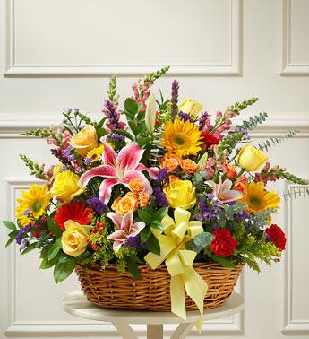 Bright Flower Sympathy Basket - Express your sympathy and compassion with this beautiful tribute arrangement of bright blooms.  Bright yellow roses and orange spray roses, lilies, sunflowers, Gerbera daisies, carnations and more, designed by our select florists in an elegant handled willow basket Friends, family and business associates can send this directly to the funeral home or to the family''s home Our florists use only the freshest flowers available, so colors and varieties may vary Arrangement measures approximately 28”H x 24”L