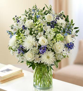 Sincerest Sorrow - Blue and White - Beautiful in blue and white, our abundant sympathy arrangement makes a fitting remembrance during difficult times. Elegant roses, snapdragons, delphinium, stock, alstroemeria, spider mums and more are tastefully arranged by our florists in a classic glass vase.  Lush blue and white arrangement of roses, snapdragons, delphinium, stock, alstroemeria, spider mums and monte casino, accented with variegated pittosporum and ruscus Hand-designed by our select florists in a classic glass cylinder vase; vase measures 8"H Can be sent to the home of friends, family members or business associates, or to the funeral service Large arrangement measures approximately 24"H x 22"L Medium arrangement measures approximately 22"H x 20"L Small arrangement measures approximately 20"H x 18"L Our florists hand-design each arrangement, so colors, varieties, and container may vary due to local availability