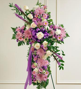 Peace and Prayers Standing Cross - Lavender - Send a beautiful and moving floral tribute that shows your support and love during this difficult time.  This standing spray arrangement – in the shape of a cross – is created from fresh flowers such as white roses and carnations, lavender daisy poms, and more. Traditionally sent directly to the funeral home by family members or friends and displayed on a stand. Our florists use only the freshest flowers available so varieties and colors may vary. Measures approximately 40"H x 26"L without easel.