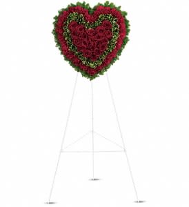 Majestic Heart - Speak from your heart. This majestic funeral display is a charming, heartfelt way to express your love, composed of sympathy red roses and carnations with variegated pittosporum and ming fern. Red carnations, red roses, variegated pittosporum and ming fern are arranged into a touching heart design that's presented on a wire easel. Orientation: One-Sided
