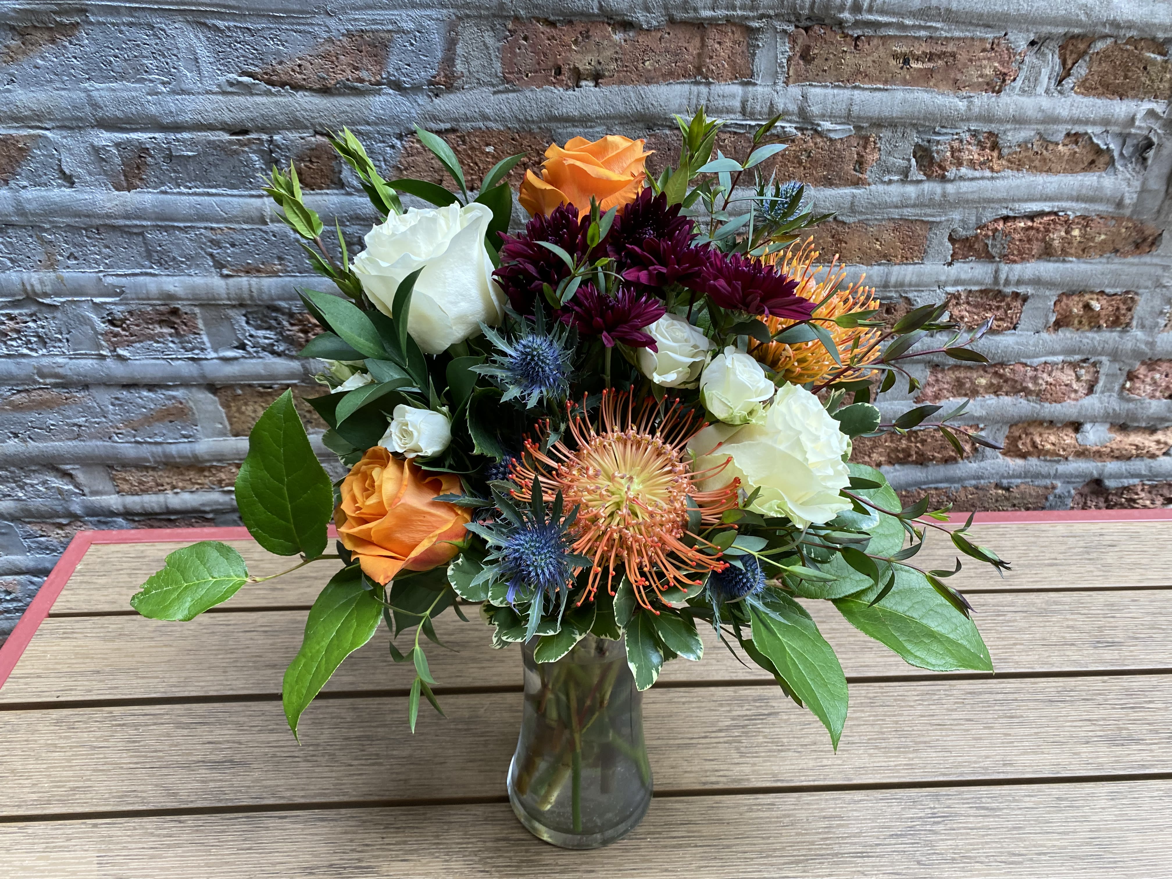 High Spirits  - A Modern Arrangement of Orange Pin Cushions and Thistle and Vibrant Greens and Roses for Pops of Color. 